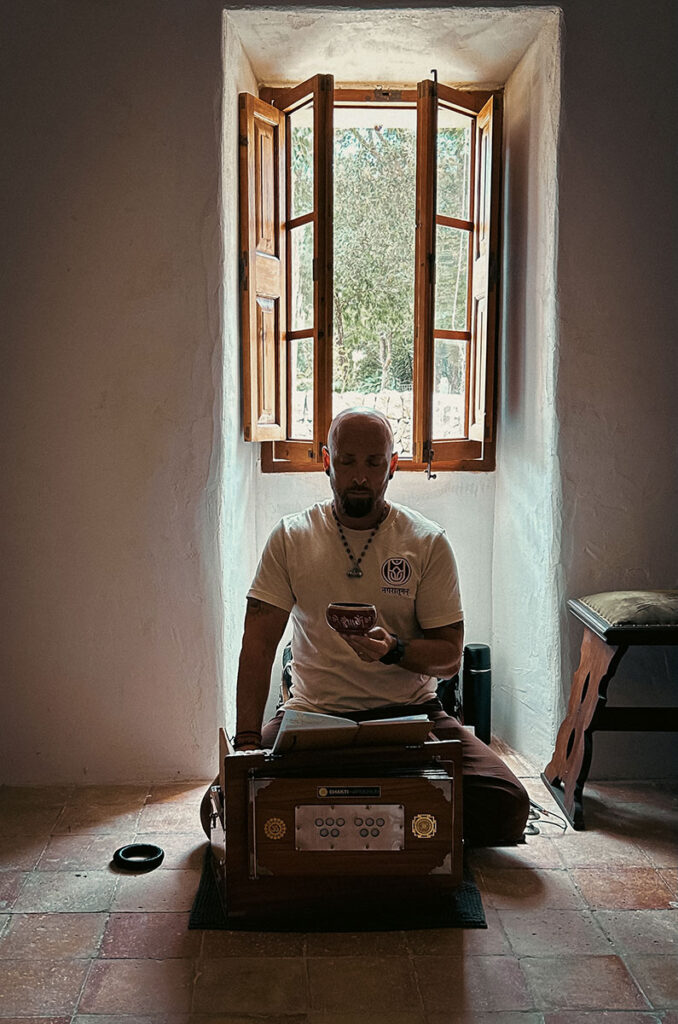 Alexander Loehr, also known as Ghanashyam Das and founder of URBAN ATMAN, guiding a Nada Yoga meditation with a Tibetan singing bowl and Indian harmonium at a meditation workshop in the old mill of SanMOLINO in Santanyí, Mallorca.