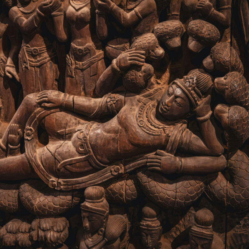 Wooden relief of Vishnu reclining on the serpent Shesha in Yoga Nidra, symbolizing the cosmic sleep of Vishnu.