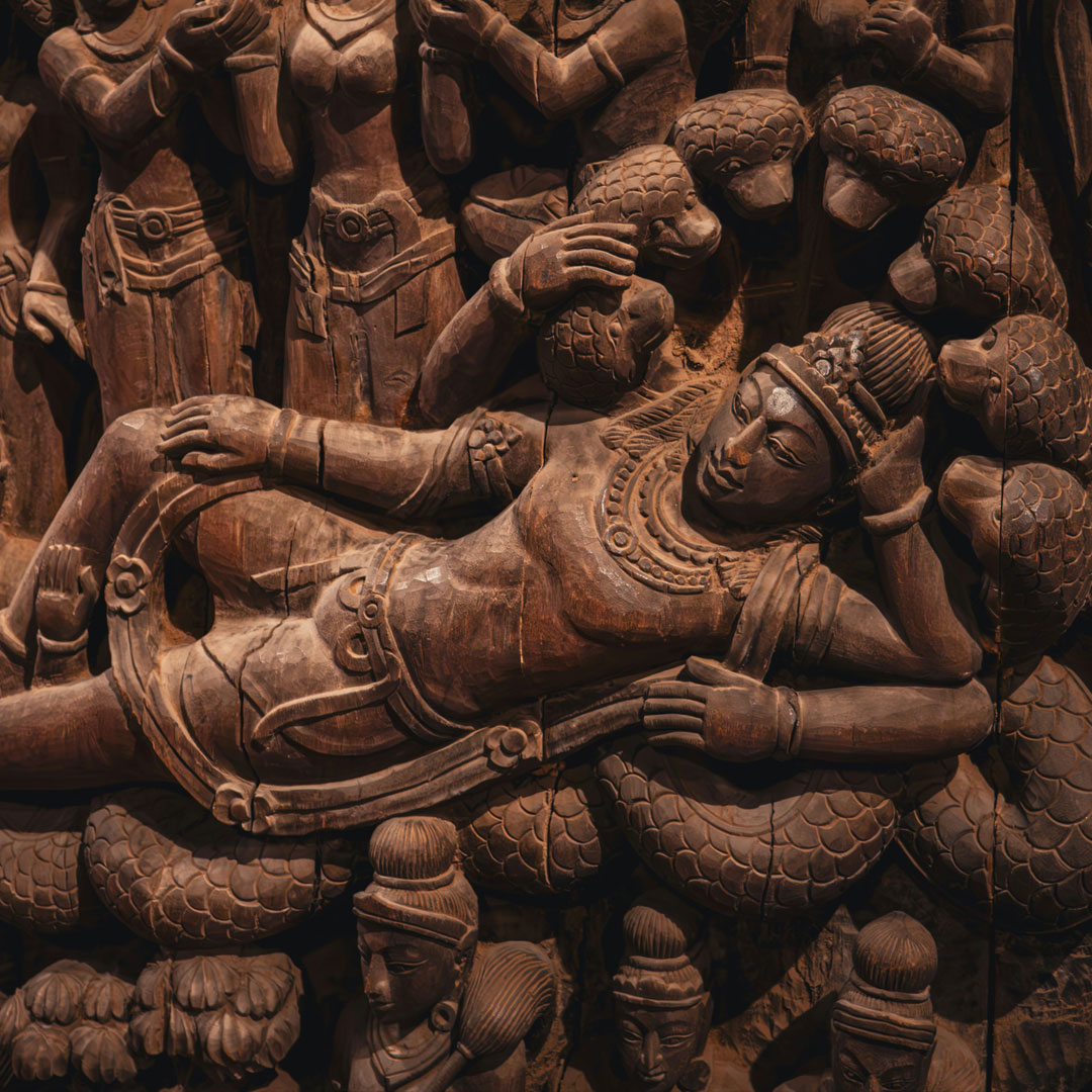 Wooden relief of Vishnu reclining on the serpent Shesha in Yoga Nidra, symbolizing the cosmic sleep of Vishnu.